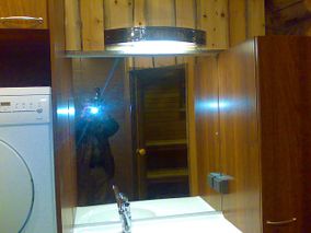 kylpyhuoneen peilistä heijastuva kameran salamavalo